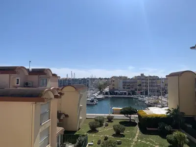 a view of a harbor with buildings and a marina at T2 Confort Centre Port 4 Pers - Clim - Parking - Ascenseur - FR-1-796-25 in Gruissan