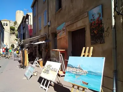 a street with paintings and easels on the side of a building at Gruissan - T2 Mezzanine Climatisé Proche Plage - 5/6 Pers - Parking Privé - Tout Équipé - FR-1-796-23 in Gruissan