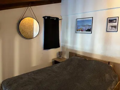 a bedroom with a bed and a mirror at Gruissan: T2 Mezzanine 6 pers, proche plage, parking privé - FR-1-796-35 in Gruissan
