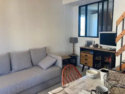 a living room with a couch and a table at Gruissan: T2 Mezzanine 6 pers, proche plage, parking privé - FR-1-796-35 in Gruissan