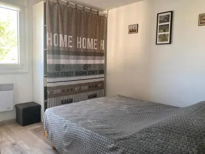a bedroom with a bed and a window with the words home home at Gruissan: T2 Mezzanine 6 pers, proche plage, parking privé - FR-1-796-35 in Gruissan