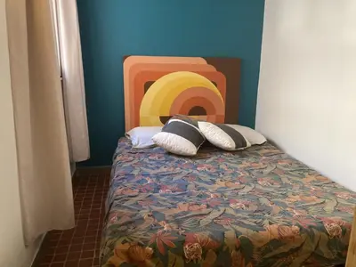 a bedroom with a bed with a rainbow and two pillows at Villa 6/7 pers climatisée - Proche port et village - Parking privé - FR-1-796-36 in Gruissan