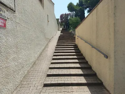 a stairway leading down a brick sidewalk next to a building at Villa 6/7 pers climatisée - Proche port et village - Parking privé - FR-1-796-36 in Gruissan