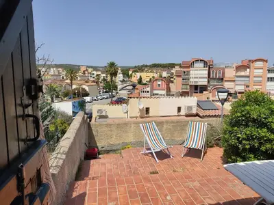 two chairs sitting on a brick patio overlooking a city at Villa 6/7 pers climatisée - Proche port et village - Parking privé - FR-1-796-36 in Gruissan