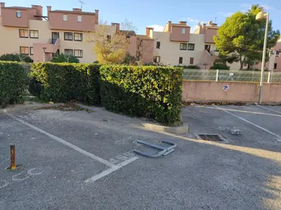 a parking lot with a hose in front of a hedge at Gruissan: T2 Spacieux 4/5 Pers, Proche Plage Grazel, Parking Privé - FR-1-796-34 in Gruissan