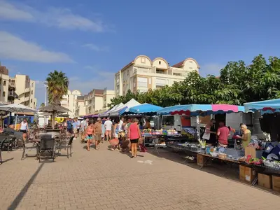 a group of people walking around an outdoor market at Gruissan: T2 Spacieux 4/5 Pers, Proche Plage Grazel, Parking Privé - FR-1-796-34 in Gruissan