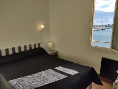 a bedroom with a bed with a view of the water at Gruissan: T2 Spacieux 4/5 Pers, Proche Plage Grazel, Parking Privé - FR-1-796-34 in Gruissan