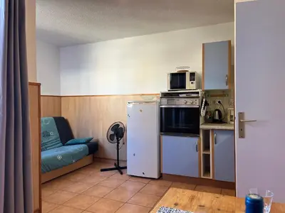 a small kitchen with a refrigerator and a microwave at Studio Familial Piscine, Parking, Proche Plage - Idéal 4 pers, Budget Serré, Gruissan - FR-1-796-58 in Gruissan