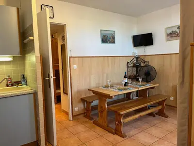a kitchen with a wooden table with wine glasses on it at Studio Familial Piscine, Parking, Proche Plage - Idéal 4 pers, Budget Serré, Gruissan - FR-1-796-58 in Gruissan