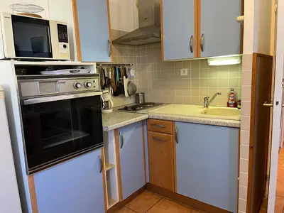 a small kitchen with white cabinets and a sink at Studio Familial Piscine, Parking, Proche Plage - Idéal 4 pers, Budget Serré, Gruissan - FR-1-796-58 in Gruissan
