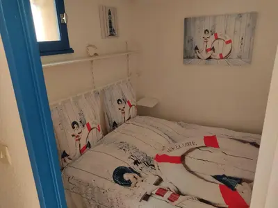 a small bedroom with a bed with a bedspread with dogs on it at **Gruissan - T2 Cabine Mezzanine - Côté Village - 6 pers - Parking Privé - Proche Plages** - FR-1-796-63 in Gruissan