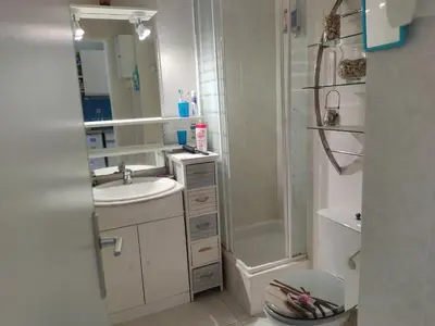 a white bathroom with a shower and a sink at Gruissan Studio Vue Mer 2/3 Pers à 50m Plage Grazel, Parking Sécurisé - FR-1-796-47 in Gruissan