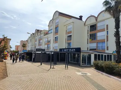 a street with a building with a sign that reads trial sushi at Gruissan Studio Vue Mer 2/3 Pers à 50m Plage Grazel, Parking Sécurisé - FR-1-796-47 in Gruissan