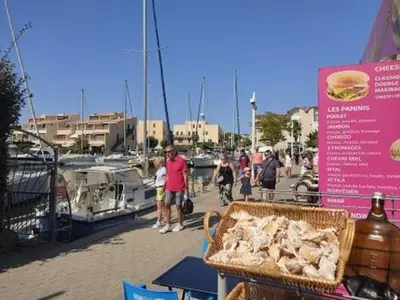 a group of people standing near a marina with boats at Gruissan - Appartement climatisé - 6 pers - Parking - Plage à 50m - FR-1-796-51 in Gruissan