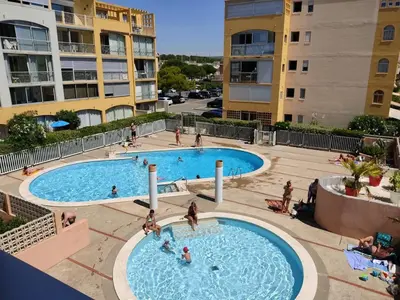 an overhead view of two swimming pools in a apartment complex at Appartement T2 moderne avec piscines, garage et proche plage - Gruissan - FR-1-796-43 in Gruissan