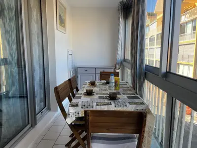 a dining room with a table and chairs on a balcony at Appartement T2 moderne avec piscines, garage et proche plage - Gruissan - FR-1-796-43 in Gruissan
