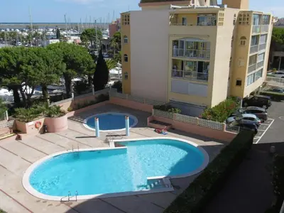 an overhead view of a swimming pool in front of a building at Appartement T2 moderne avec piscines, garage et proche plage - Gruissan - FR-1-796-43 in Gruissan