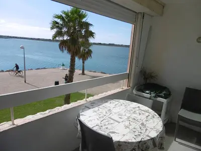 a room with a table and a view of the water at Gruissan - T2 Vue Mer - 4 Pers - Parking Privé - FR-1-796-46 in Gruissan