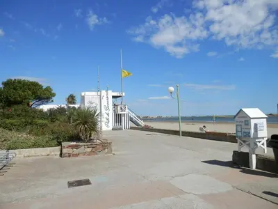 a walkway next to a beach with a lighthouse at Villa Confortable 6 Pers. Climatisée, Proche Plage du Grazel, Calme, Tout Équipée, Stationnement Inclus - FR-1-796-71 in Gruissan