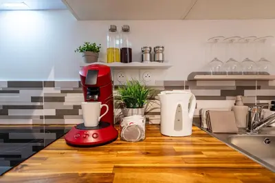 a red mixer sitting on top of a kitchen counter at L'Occitane - Grand Studio Chaleureux en Hyper centre in Castres