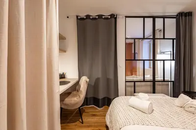a bedroom with a bed and a desk and a window at L'Occitane - Grand Studio Chaleureux en Hyper centre in Castres