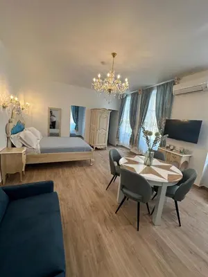 a living room with a bed and a table and chairs at Appartement du Cloitre 1er in Narbonne