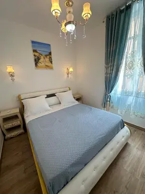 a bed in a bedroom with a chandelier at Appartement du Cloitre 1er in Narbonne