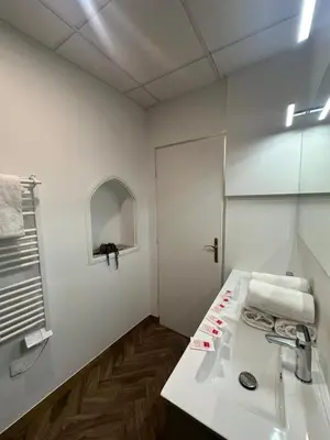 a white bathroom with a sink and a mirror at Appartement du Cloitre 1er in Narbonne
