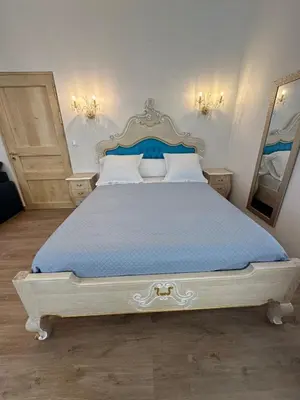 a bedroom with a large bed with a blue bedspread at Appartement du Cloitre 1er in Narbonne
