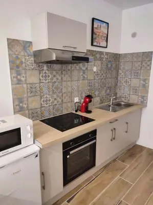 a small kitchen with a sink and a microwave at Charmant T2 au cœur de Narbonne in Narbonne