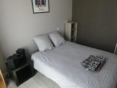 a bedroom with a bed with a white comforter at La Courtine, centre historique Narbonne in Narbonne
