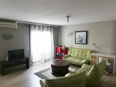 a living room with a yellow couch and a television at La Courtine, centre historique Narbonne in Narbonne