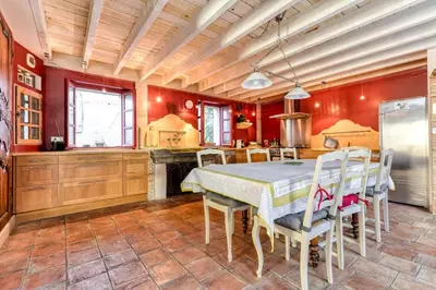a kitchen with a table and chairs and red walls at Loft centre-ville Parking, clim, wifi in Carcassonne