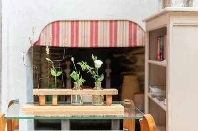 a glass table with two vases with flowers on it at Loft centre-ville Parking, clim, wifi in Carcassonne