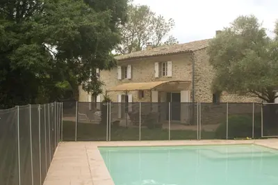 a house with a fence and a swimming pool at Le Moulin, avec parc, piscine, au cœur du village in Villegly