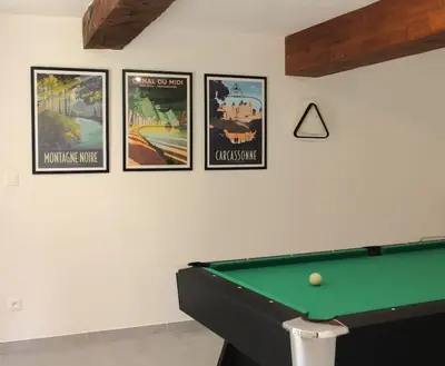 four posters on a wall with a pool table at Le Moulin, avec parc, piscine, au cœur du village in Villegly
