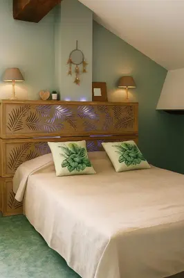 a bedroom with a large bed with two pillows at Sous les toits in Narbonne