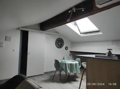 a kitchen with a table with chairs and a sink at Sous les toits in Narbonne