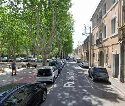 a street with cars parked on the side of the road at Sous les toits in Narbonne