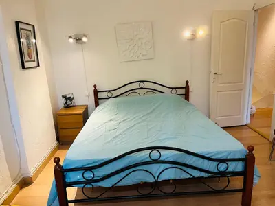 a bedroom with a bed with a blue comforter at Maison de village in Peyriac-Minervois