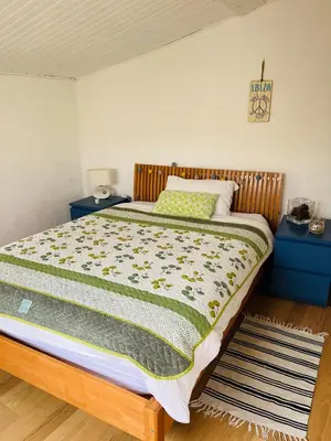 a bed in a bedroom with two night stands and two tables at Maison de village in Peyriac-Minervois