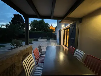 a wooden table and chairs on a patio at La Vade in Carcassonne