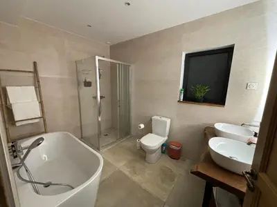 a bathroom with two sinks and a tub and a toilet at La Vade in Carcassonne