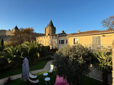 a view of a garden with a castle in the background at La Vade in Carcassonne