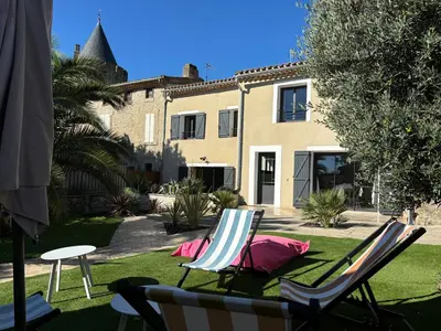 a couple of lawn chairs sitting on the grass in front of a house at La Vade in Carcassonne