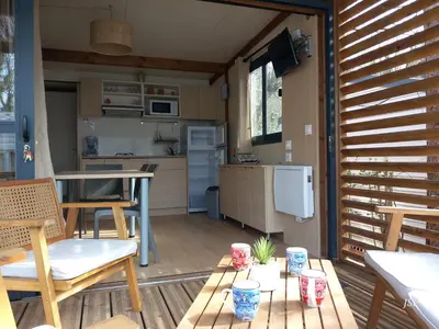 a small kitchen with a table and chairs on a deck at Chalet Zen in Vaudreuille