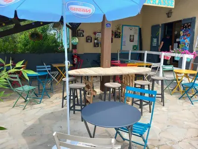 a table and chairs with an umbrella on a patio at Chalet Zen in Vaudreuille