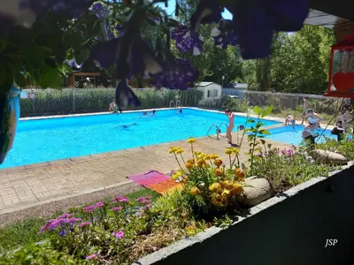 a swimming pool with people playing in it at Chalet Zen in Vaudreuille