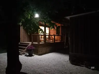 a porch of a log cabin at night at Chalet Zen in Vaudreuille