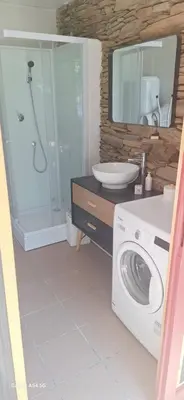 a bathroom with a washing machine and a sink at Au Grand Mûrier in Roquefère